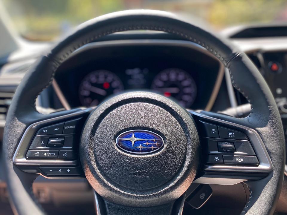The steering wheel of a Subaru Ascent is seen from the driver's seat.