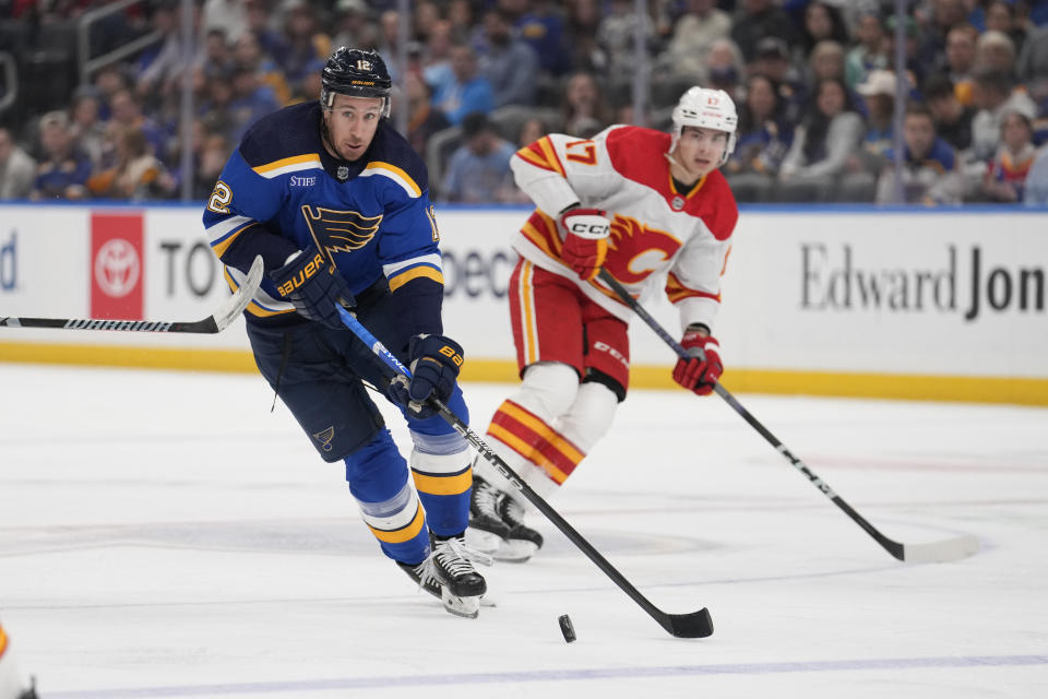 St. Louis Blues' Kevin Hayes (12) controls the puck as Calgary Flames' Yegor Sharangovich (17) defends during the second period of an NHL hockey game Thursday, March 28, 2024, in St. Louis. (AP Photo/Jeff Roberson)