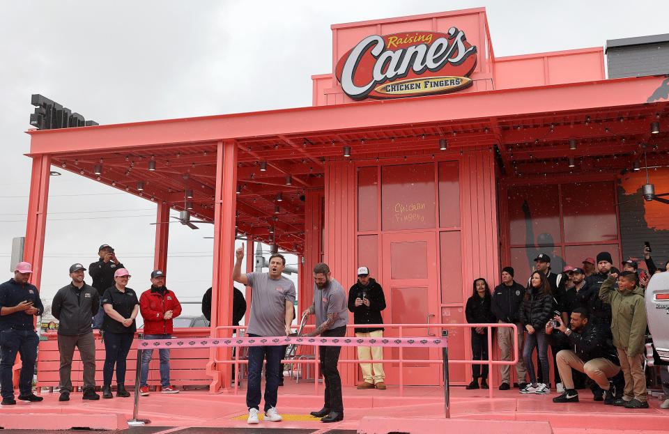 Raising Cane’s founder Todd Graves and Post Malone get ready to cut the ribbon during the grand opening ribbon-cutting for a Raising Cane’s Restaurant, designed by the singer, in Midvale on Thursday, April 13, 2023. | Kristin Murphy, Deseret News