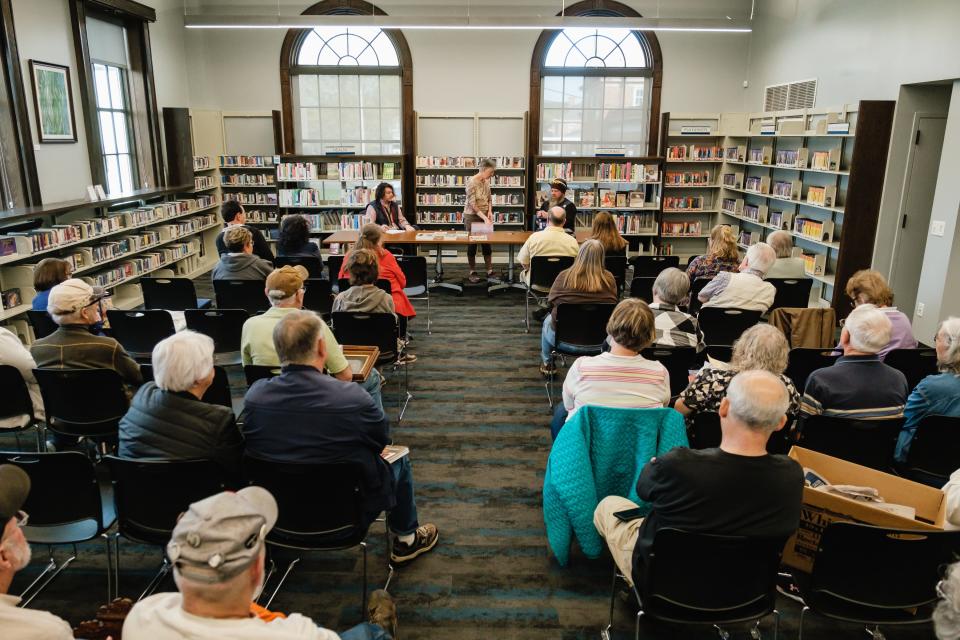 People watch and listen to Jason Adams, at top right, as he appraises antiques Thursday at the New Philadelphia branch of the Tuscarawas County Library.