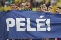 Brazilian players hold a banner in honour of the 82-year-old Brazilian soccer legend Pele who is in a hospital in San Paulo recovering from a respiratory infection at the end of the World Cup round of 16 soccer match between Brazil and South Korea at the Stadium 974 in Doha, Qatar, Monday, Dec. 5, 2022. (AP Photo/Jin-Man Lee)