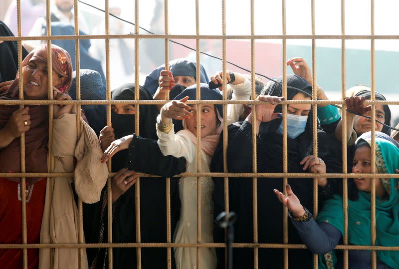 Afghan women wait to receive tokens needed to apply for the Pakistan visa, after some people were killed in a stampede in Jalalabad