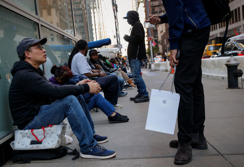 Customers wait in line for the new iPhone X outside an Apple store in New York City