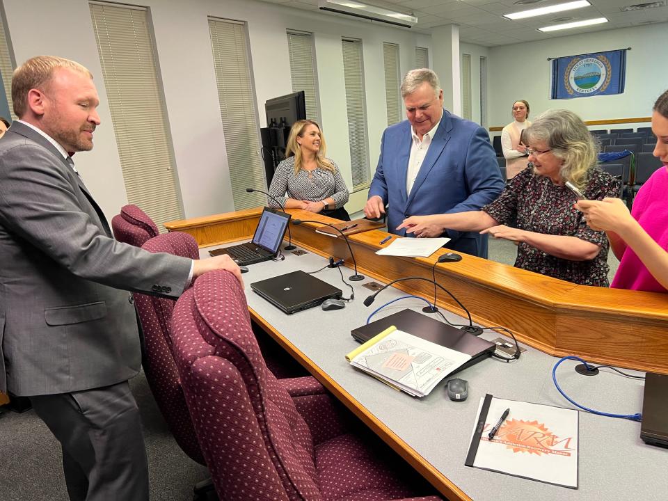 Jagoe Homes co-owner Bill Jagoe (center) finishes signing paperwork Tuesday afternoon to purchase 86 acres from the city of Henderson for $1.55 million for a new 300-home subdivision. Mayor Brad Staton and Henderson Economic Development Executive Director Missy Vanderpool, at left, look on while City Clerk Maree Collins reaches for the paperwork and city Public Information Officer Holli Melton photographs the moment.