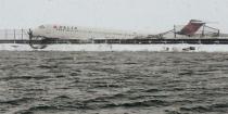 A Delta jet which skidded off the runway at Laguardia airport is seen jutting above a dyke in New York City March 5, 2015, in a photo provided by the New York Police Department. REUTERS/New York Police Department/handout via Reuters