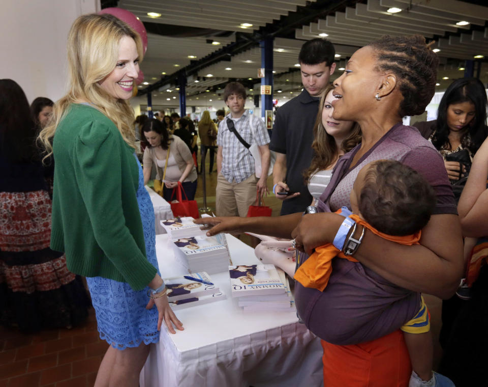 This May 18, 2013 photo shows pregnancy advise guru Rosie Pope, center, speaking with attendees at the New York Baby Show in New York. Pope is the author of the pregnancy guide, "Mommy IQ," and also has her own maternity clothing line. (AP Photo/Richard Drew, file)