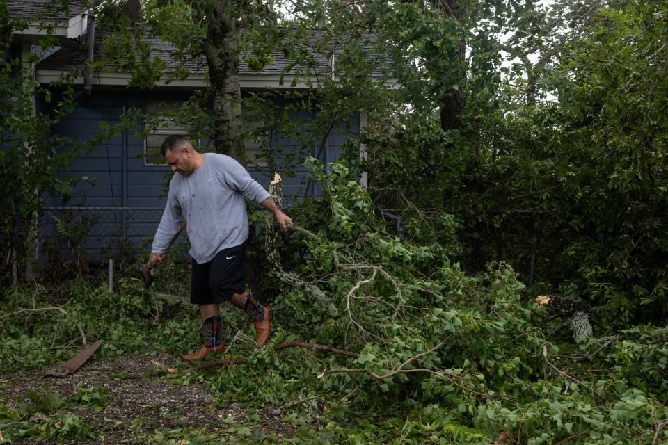 Roberto Garcia, 43, clears tree branches from his mother's property in the aftermath of Hurricane Beryl in Freeport, Texas, July 8, 2024.