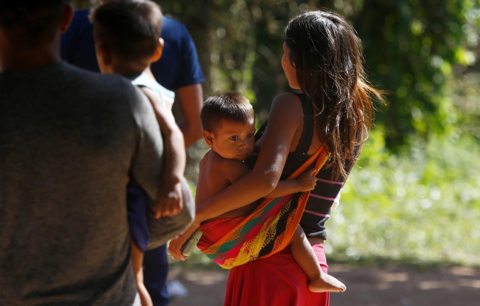 A Yanomami woman carries a toddler on the property of the Saude Indigenous House, a center responsible for supporting and assisting Indigenous people in Boa Vista, Roraima state, Brazil, Wednesday, Jan. 25, 2023. The government declared a public health emergency for the Yanomami people in the Amazon, who are suffering from malnutrition and diseases such as malaria. (AP Photo/Edmar Barros)