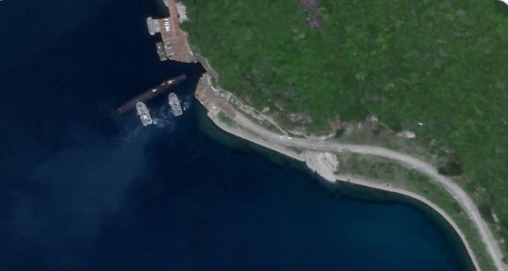 衛星拍到在兩艘軍艦下的一艘中國潛艇，正要進入位在海南島的地下基地。 圖 : 取自Drake Long推特