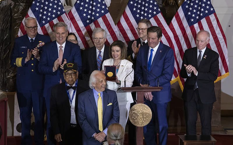 Veterans Dave Yoho and Charles Mills accept a Congressional Gold Medal from Speaker Pelosi