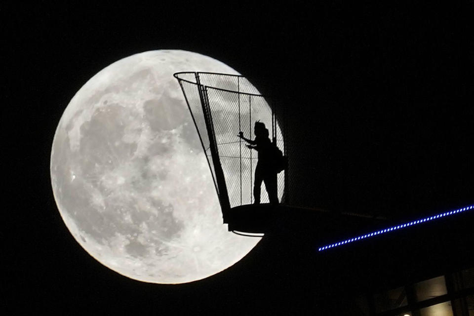 A harvest moon is seen behind Osaka's landmark Tsutenkaku Tower on Sept. 29, 2023. (