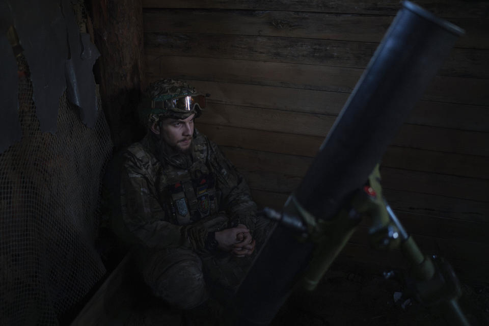 A Ukrainian serviceman from the Azov brigade, known by the call sign Buk, 24, waits for a command to fire, at positions of 122 mm HM 16 mortar around one kilometer away from Russian forces on the frontline in Kreminna direction, Donetsk region, Ukraine, Friday, April 12, 2024. (AP Photo/Alex Babenko)