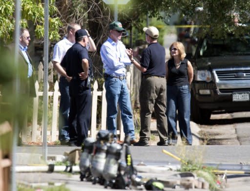 Oficiales de la Policía hablan con el gobernador de Colorado John Hickenlooper (C) frente al apartamento del autor de los disparos, James Holmes, el 21 de julio de 2012 en Aurora, Colorado. (AFP | don emmert)