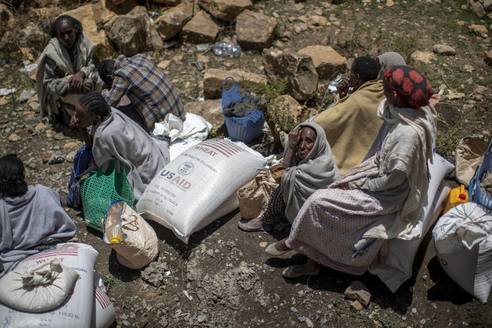 FILE - An Ethiopian woman sits next to a sack of wheat after it was distributed to her by the Relief Society of Tigray in the town of Agula, in the Tigray region of northern Ethiopia on May 8, 2021. In 2023 urgently needed grain and oil have disappeared again for millions caught in a standoff between Ethiopia's government, the United States and United Nations over what U.S. officials say may be the biggest theft of food aid on record. (AP Photo/Ben Curtis, File)