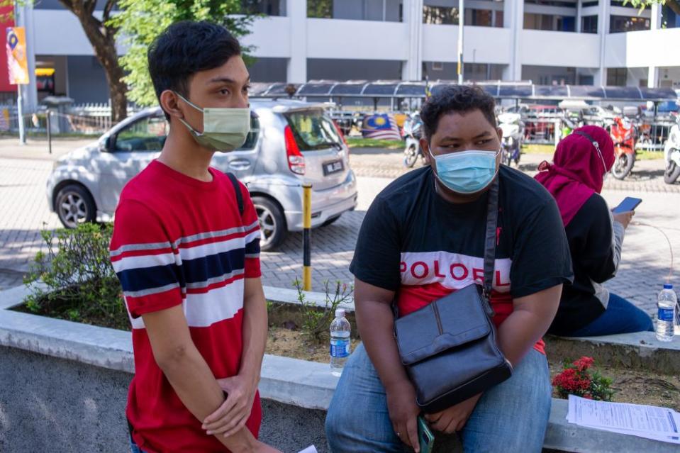 Ahmad Rasdan (right) and Mohd Shafiq Abdul Rahim speak to reporters outside the Axiata Arena Covid-19 vaccination centre in Bukit Jalil September 23, 2021. — Picture by Shafwan Zaidon