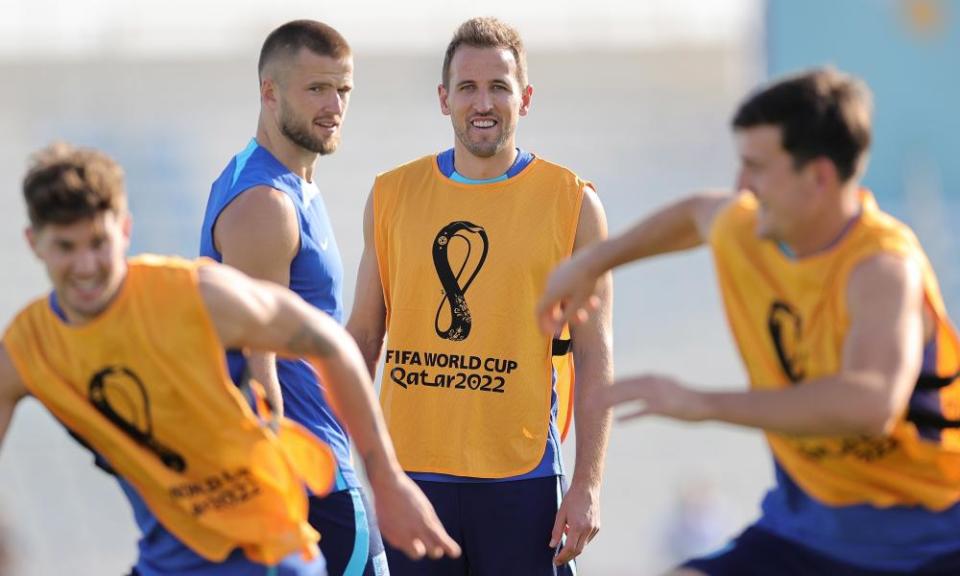 Harry Kane watches on with a grin as John Stones and Harry Maguire battle it out in training