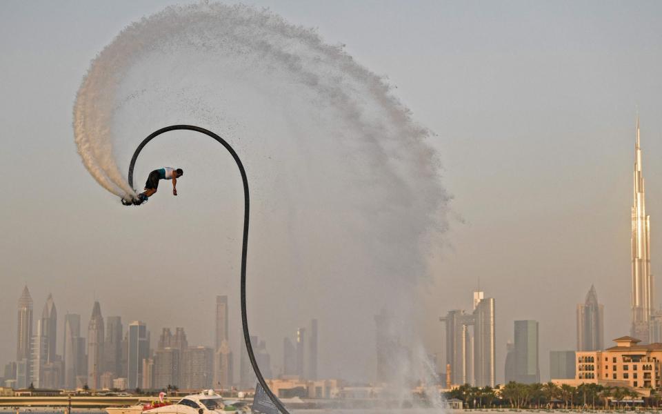 An athlete performs stunts with a water jet pack on the first day of the Dubai watersport festival, organised by the Dubai International Marine Club (DIMC), near the Burj Khalifa - KARIM SAHIB/AFP