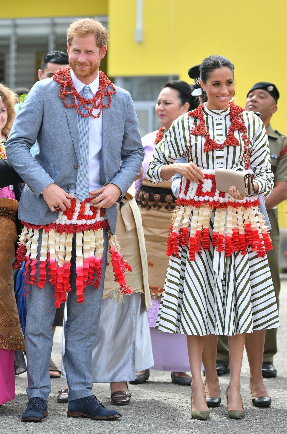 Meghan and Harry received a lively welcome to Tonga, being given <a rel="nofollow noopener" href="https://people.com/royals/meghan-markle-prince-harry-meet-tonga-craftsmen-traders/" target="_blank" data-ylk="slk:traditional Tonga garlands;elm:context_link;itc:0;sec:content-canvas" class="link ">traditional Tonga garlands</a> to wear during their visit to the Fa’onelua Convention Centre.