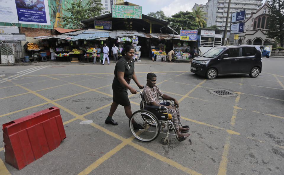 A Sri Lankan army soldier wheels another soldier to a medical clinic outside the National Hospital during a day long token strike by the members of Government Medical Officers Association in Colombo, Sri Lanka, Wednesday, Sept. 18, 2019. The trade union action is to demand the government resolve salary anomalies faced by the doctors serving at state-run hospitals. (AP Photo/Eranga Jayawardena)