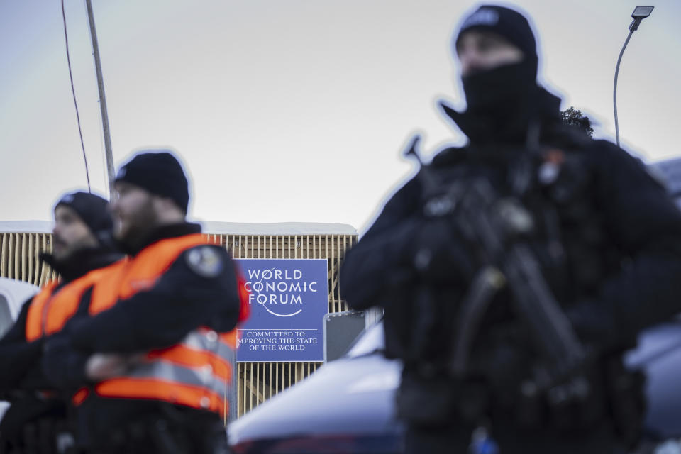 Police stand guard near the logo of the WEF during a press conference of police and army regarding security prior the 54th annual meeting of the World Economic Forum, WEF, in Davos, Switzerland, Friday, Jan. 12, 2024. The meeting brings together entrepreneurs, scientists, corporate and political leaders in Davos under the topic "Rebuilding Trust" from 15 to 19 January. (Gian Ehrenzeller/Keystone via AP)