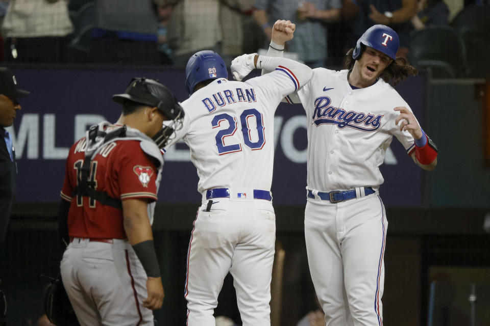 Texas Rangers' Ezequiel Duran, left, celebrates with Jonah Heim, right, after hitting a two-run home run against the Arizona Diamondbacks during the sixth inning of a baseball game against the Texas Rangers, Tuesday, May 2, 2023, in Arlington, Texas. (AP Photo/Michael Ainsworth)