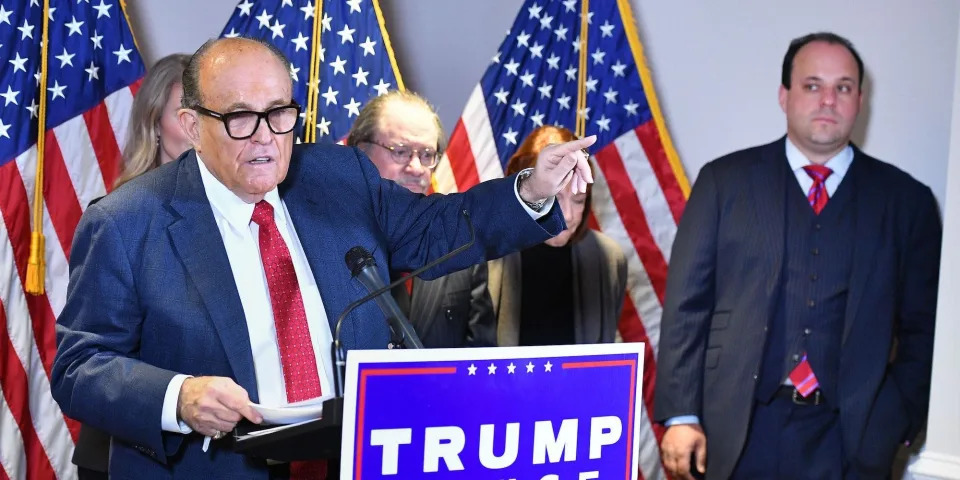 A November 19, 2020 photo shows the personal lawyer of US President Donald Trump, Rudy Giuliani, speaking at a press conference watched by Trump campaign advisor Boris Epshteyn (R), at the Republican National Committee headquarters in Washington, DC.