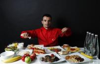 Turkish weightlifter and Olympic hopeful Mete Binay, 27, poses in front of his daily meal intake in Ankara May 29, 2012.