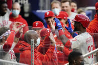 Philadelphia Phillies' Odubel Herrera is greeted at the dugout by teammates after hitting a three-run home run in the first inning of a baseball game against the Atlanta Braves, Friday, May 7, 2021, in Atlanta. (AP Photo/John Bazemore)