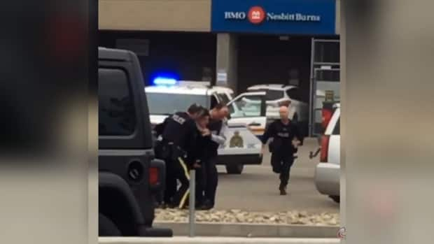 Const. Siggy Pietrzak is seen running in a still image taken from a video that captures the arrest of Tyler Russell in Kelowna on May 30, 2020.  (Castanet - image credit)