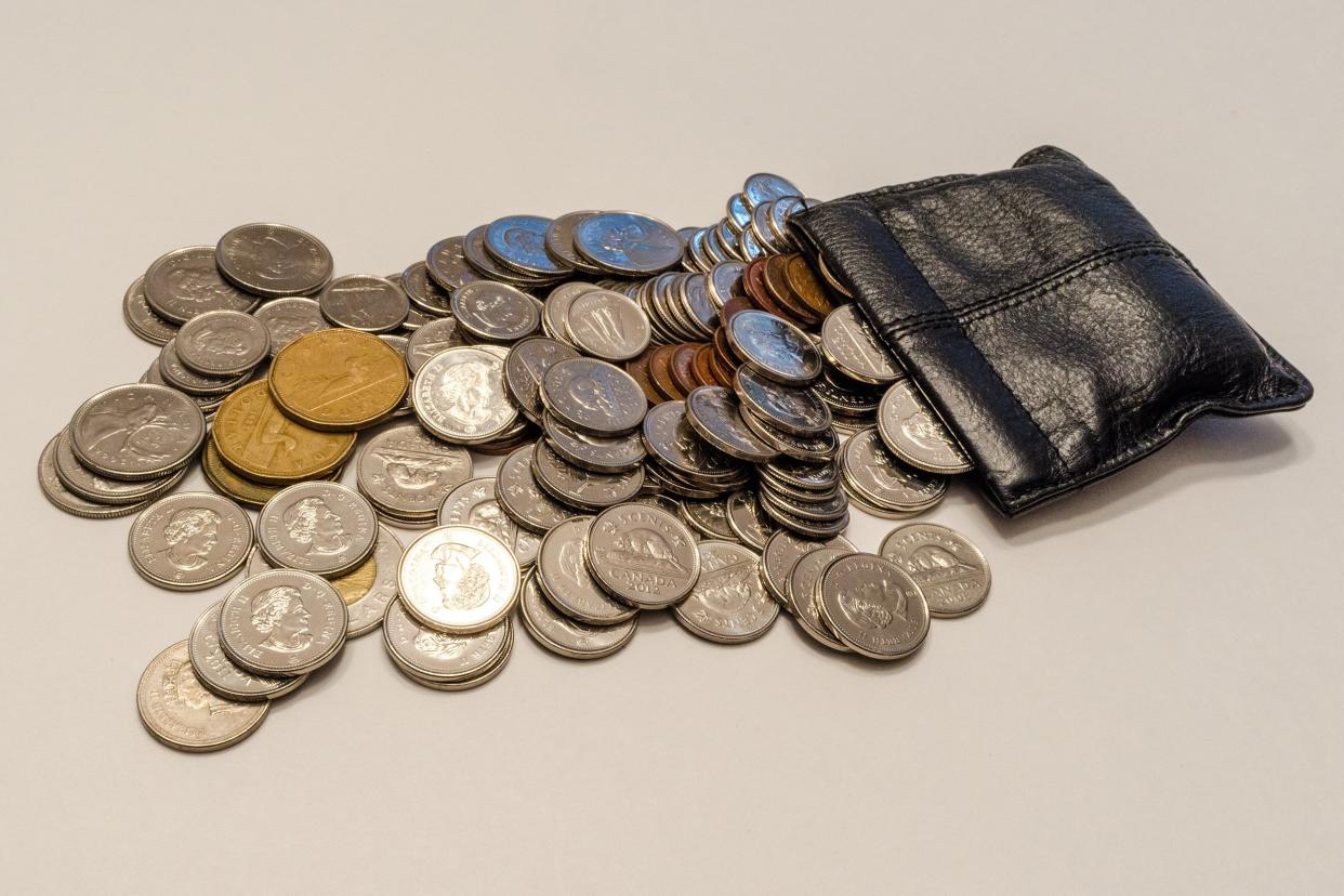 Canadian coins flowing from a leather pouch