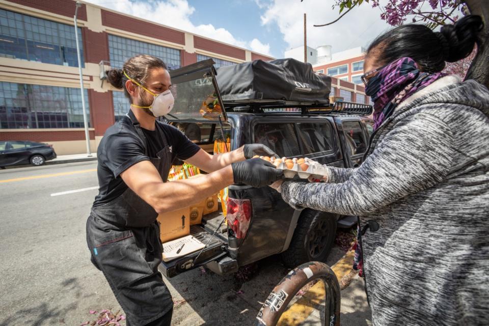 Damian Diaz of No Us Without You distributes fresh eggs to a family in Boyle Heights