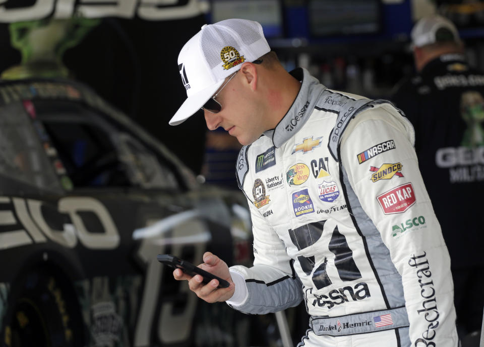 Daniel Hemric checks his phone in his garage before the start of a NASCAR auto race practice at Daytona International Speedway, Thursday, July 4, 2019, in Daytona Beach, Fla. (AP Photo/Terry Renna)