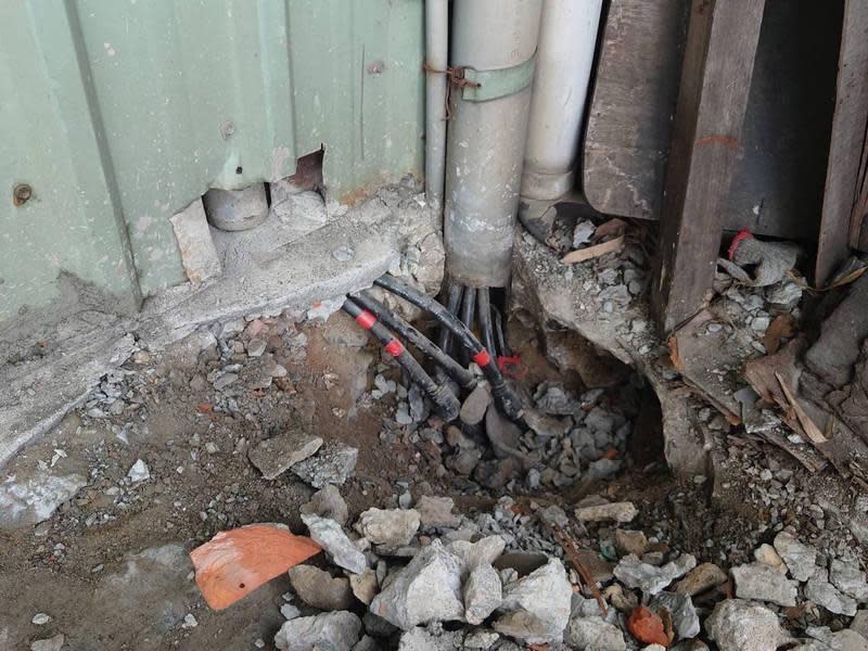 台電人員撬開水泥，才找到埋在地面下的竊電電線。（讀者提供）