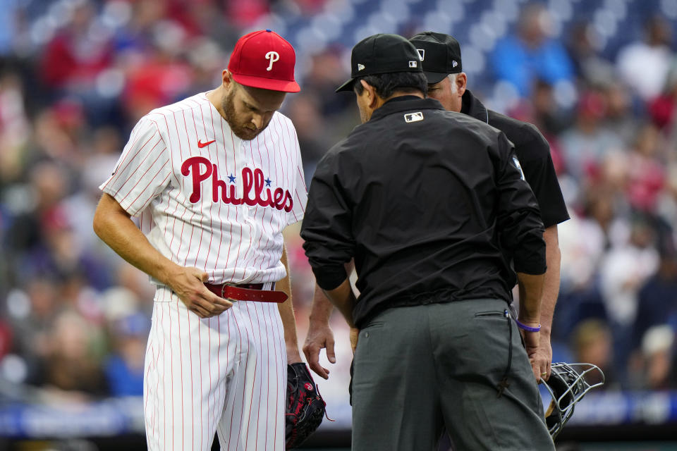 Philadelphia Phillies pitcher Zack Wheeler, left, is checked by umpires after the first inning of a baseball game against the Washington Nationals, Tuesday, June 22, 2021, in Philadelphia. (AP Photo/Matt Slocum)