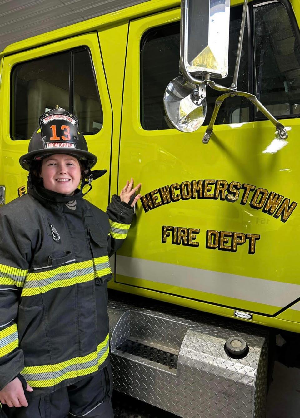 Haley Durben stands beside a Newcomerstown fire truck. She is the first female firefighter on the village's fire department.