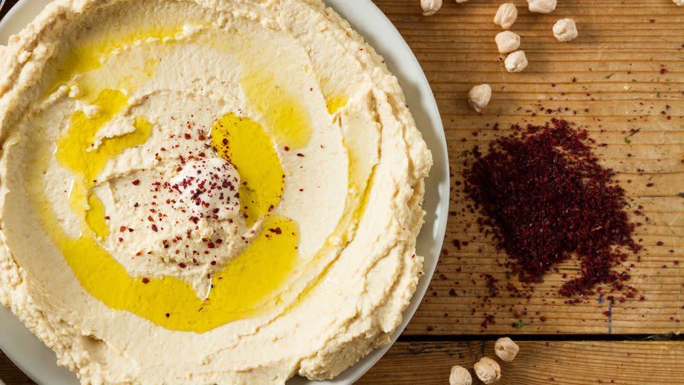 Serve up hummus in a spread made from chickpeas and seasoned with sumac and oil. Sumac can bring out the natural flavors of food much like salt does. - Ionut Groza/500px/Getty Images