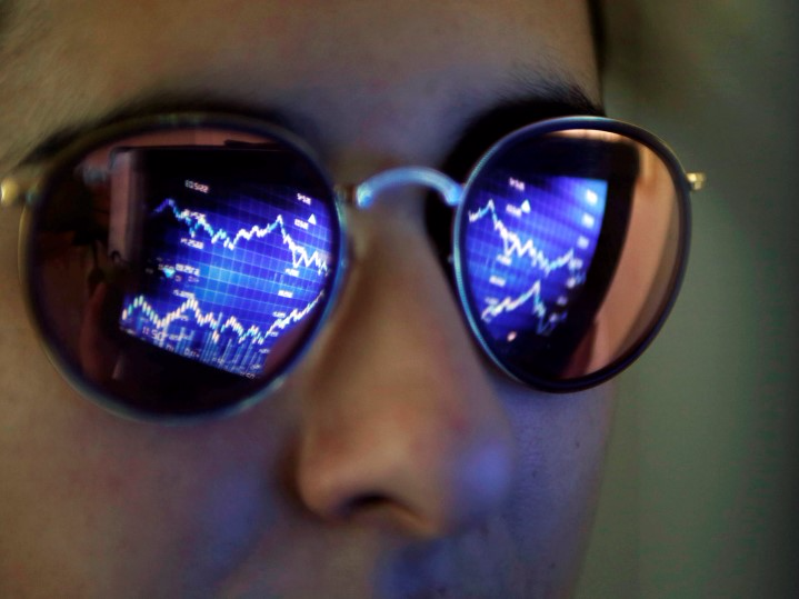 A computer screen showing stock graphs is reflected on glasses in this illustration photo taken in Bordeaux, France, March 30, 2016. REUTERS/Regis Duvignau 