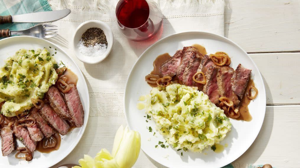 a table with plates of food and glasses of wine