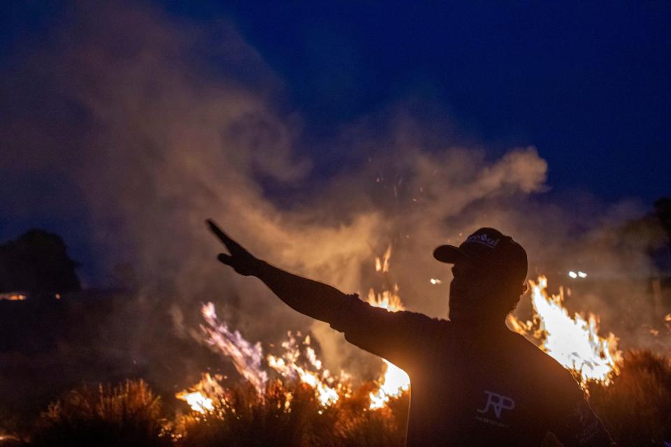 A laborer gestures as he looks at a fire that spread to the farm he works on next to a highway in Nova Santa Helena municipality in northern Mato Grosso State, south in the Amazon basin in Brazil, on Aug. 23, 2019. (Photo: Joao Laet/AFP/Getty Images)