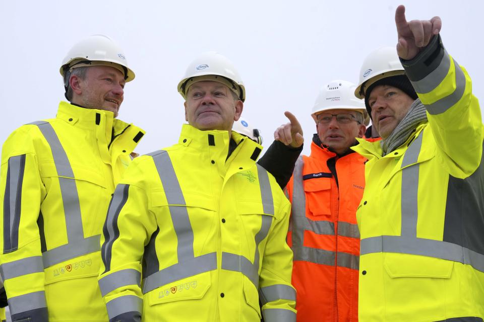 German Chancellor Olaf Scholz, second left, German Economy and Climate Minister Robert Habeck, right, and German Finance Minister Christian Lindner, left, listen during an event in front of the 'Hoegh Esperanza' Floating Storage and Regasification Unit (FSRU) during the opening of the LNG (Liquefied Natural Gas) terminal in Wilhelmshaven, Germany, Saturday, Dec. 17, 2022. (AP Photo/Michael Sohn, pool)