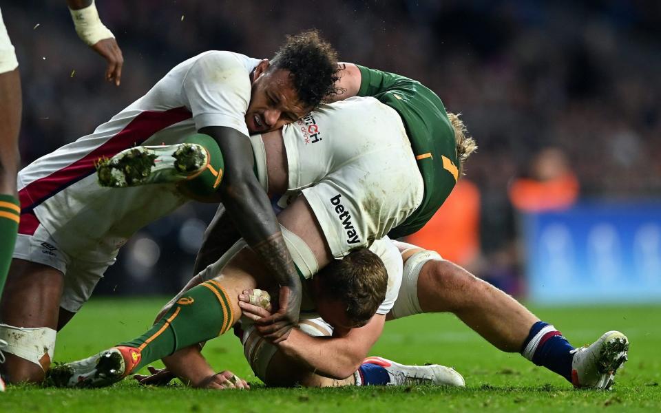 Courtney Lawes and Sam Underhill of England double-tackle Kwagga Smith of South Africa England v South Africa - Shutterstock/Patrick Khachfe