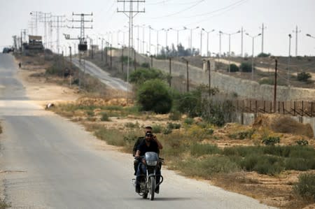 Members of Palestinian security forces loyal to Hamas ride a motorcycle as they patrol the border area with Egypt, in the southern Gaza Strip
