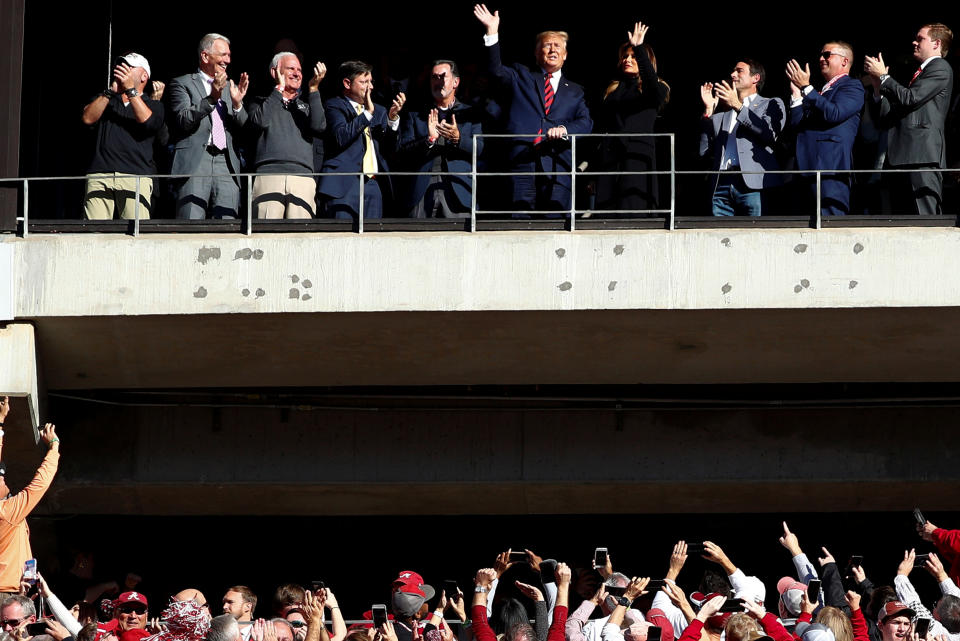 U.S. President Donald Trump and first lady Melania Trump wave to the crowd during a game between LSU and Alabama (Reuters)