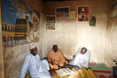 Shi'ite men talk while sitting under posters of their Islamic leaders in Zaria, Kaduna state, Nigeria, February 2, 2016. REUTERS/Afolabi Sotunde