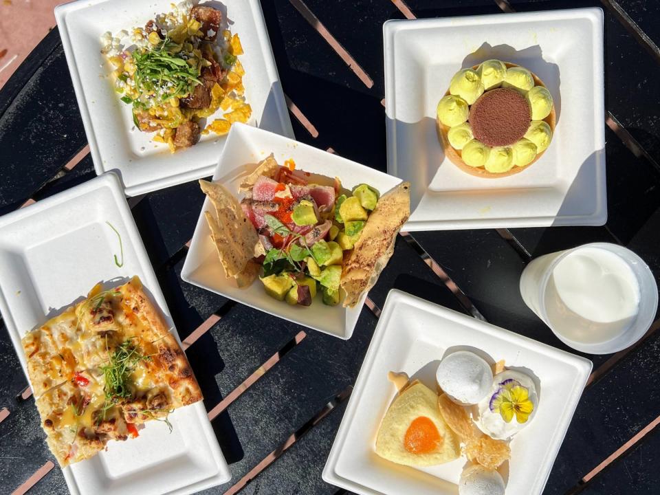 plates of food from epcot festival booths on a black picnic table