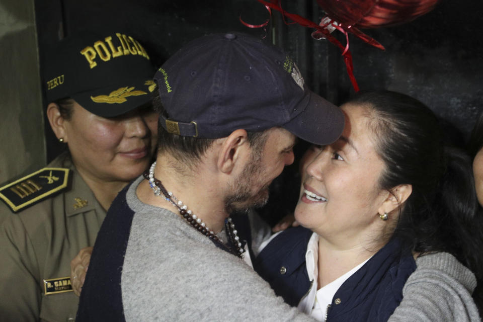 Keiko Fujimori, right, is embraced by her husband Mark Vito Villanela after being released from the Santa Mónica women's prison in Lima, Peru, Friday, Nov. 29, 2019. The Constitutional Tribunal narrowly approved a habeas corpus request to free Fujimori from detention while she is investigated for alleged accusations she accepted money from Brazilian construction giant Odebrecht.(AP Photo/Martin Mejia)