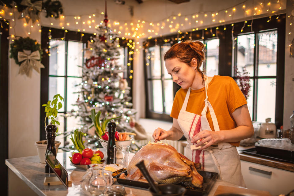 woman preparing stuffed turkey for Christmas dinner