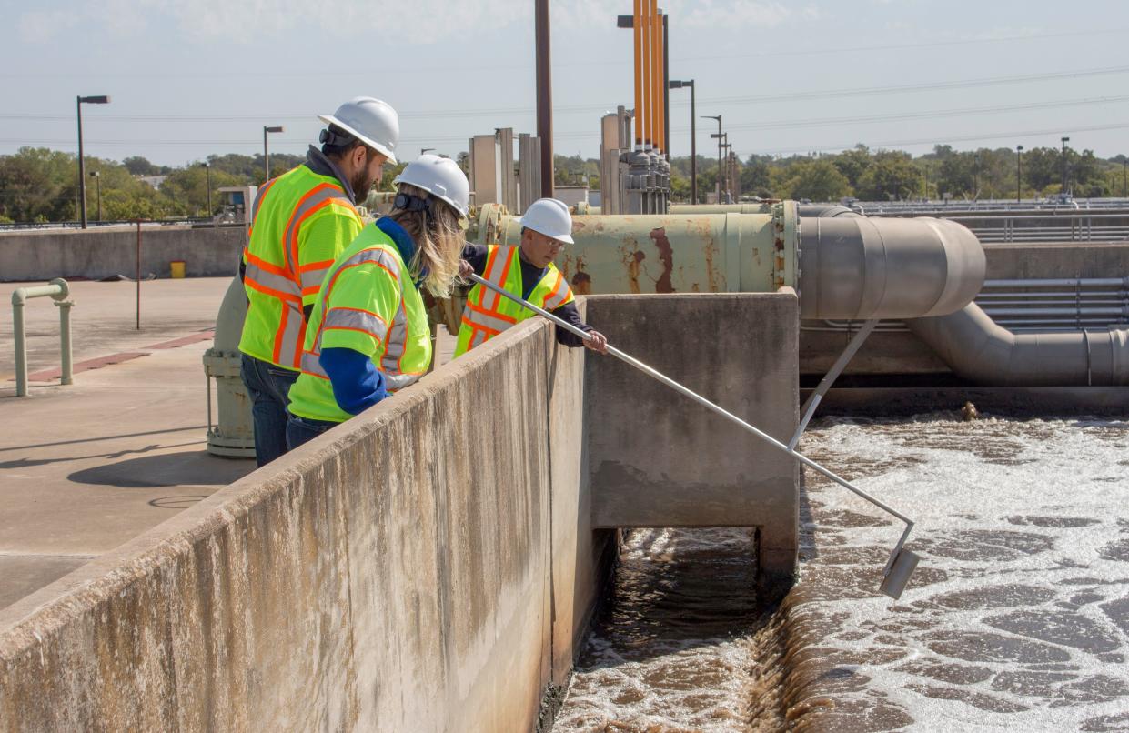 Workers at Austin's Walnut Creek Wastewater Treatment Plant collect samples in 2018 to monitor the wastewater treatment process. This week, workers will begin collecting samples for a new vendor, Verily, to test for the prevalence of COVID-19 in the community.