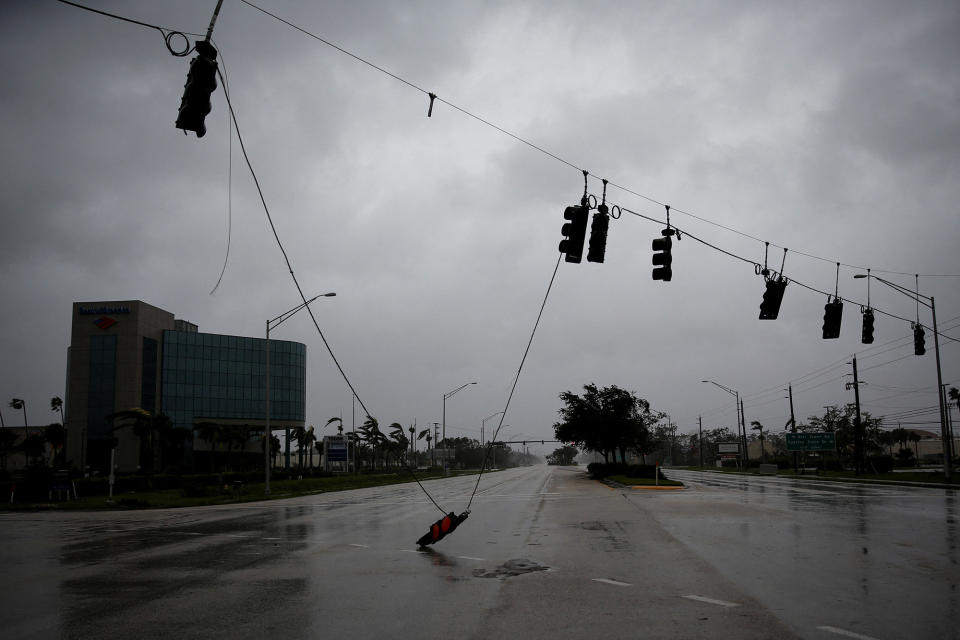 A fallen traffic light dangles from a wire as Hurricane Ian makes landfall in Fort Myers on Sept. 28, 2022.