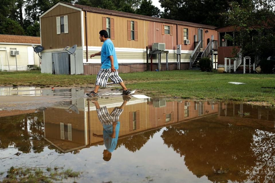 Angel Flores checks the condition of friends’ manufactured homes on Sept. 17, 2018, in Kinston, North Carolina, three days after Hurricane Florence made landfall in the state. <a href="https://www.gettyimages.com/detail/news-photo/auto-mechanic-angel-flores-walks-past-flood-waters-as-he-news-photo/1034838886" rel="nofollow noopener" target="_blank" data-ylk="slk:Chip Somodevilla/Getty Images;elm:context_link;itc:0;sec:content-canvas" class="link ">Chip Somodevilla/Getty Images</a>